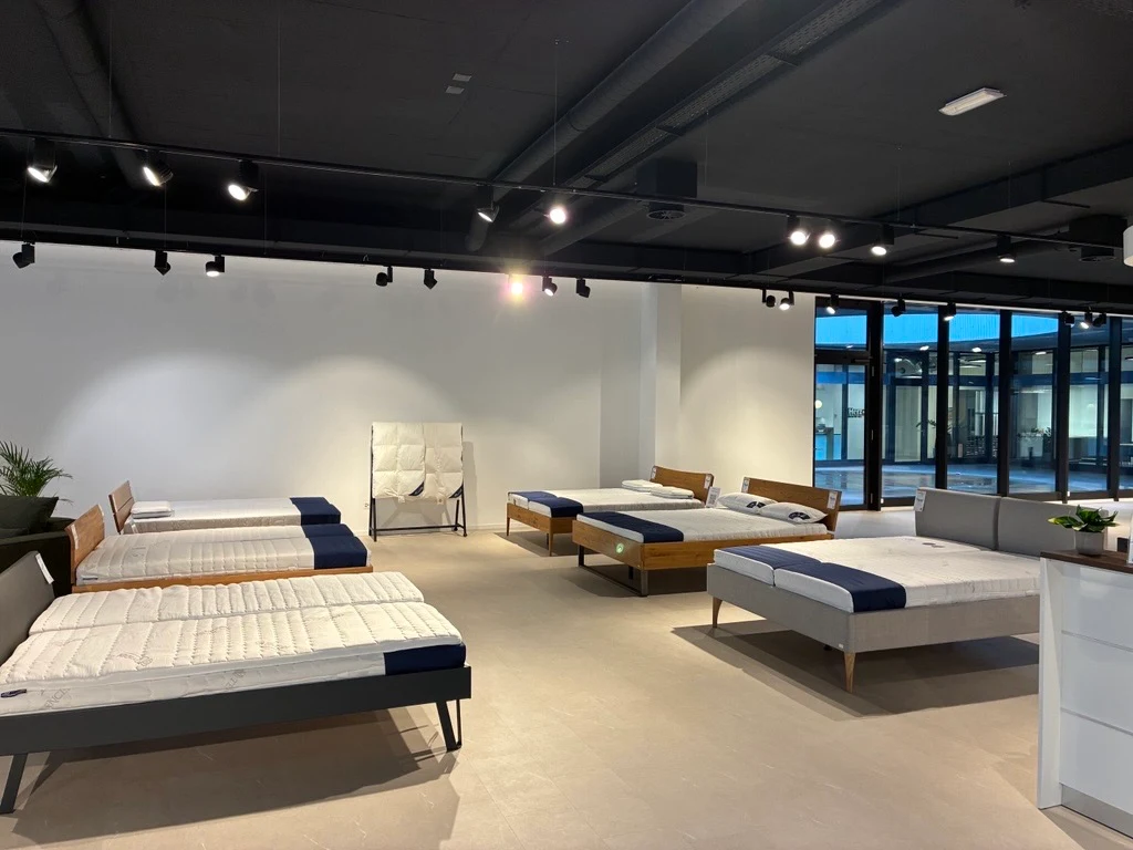 Blick in den Ausstellungsraum in Schlieren bei Zürich mit mehreren Betten und Matratzen von AM Qualitätsmatratzen.